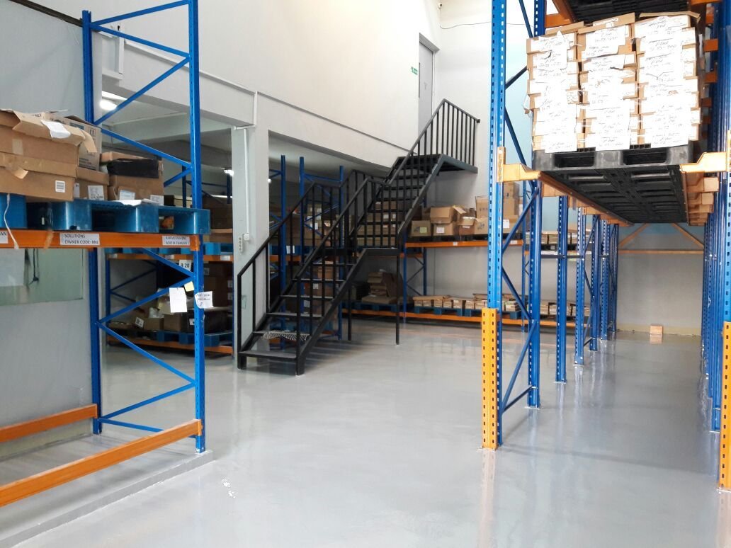 Pengerjaan epoxy lantai gudang logistik oleh CV Topo Group dengan jalur forklift yang jelas.
